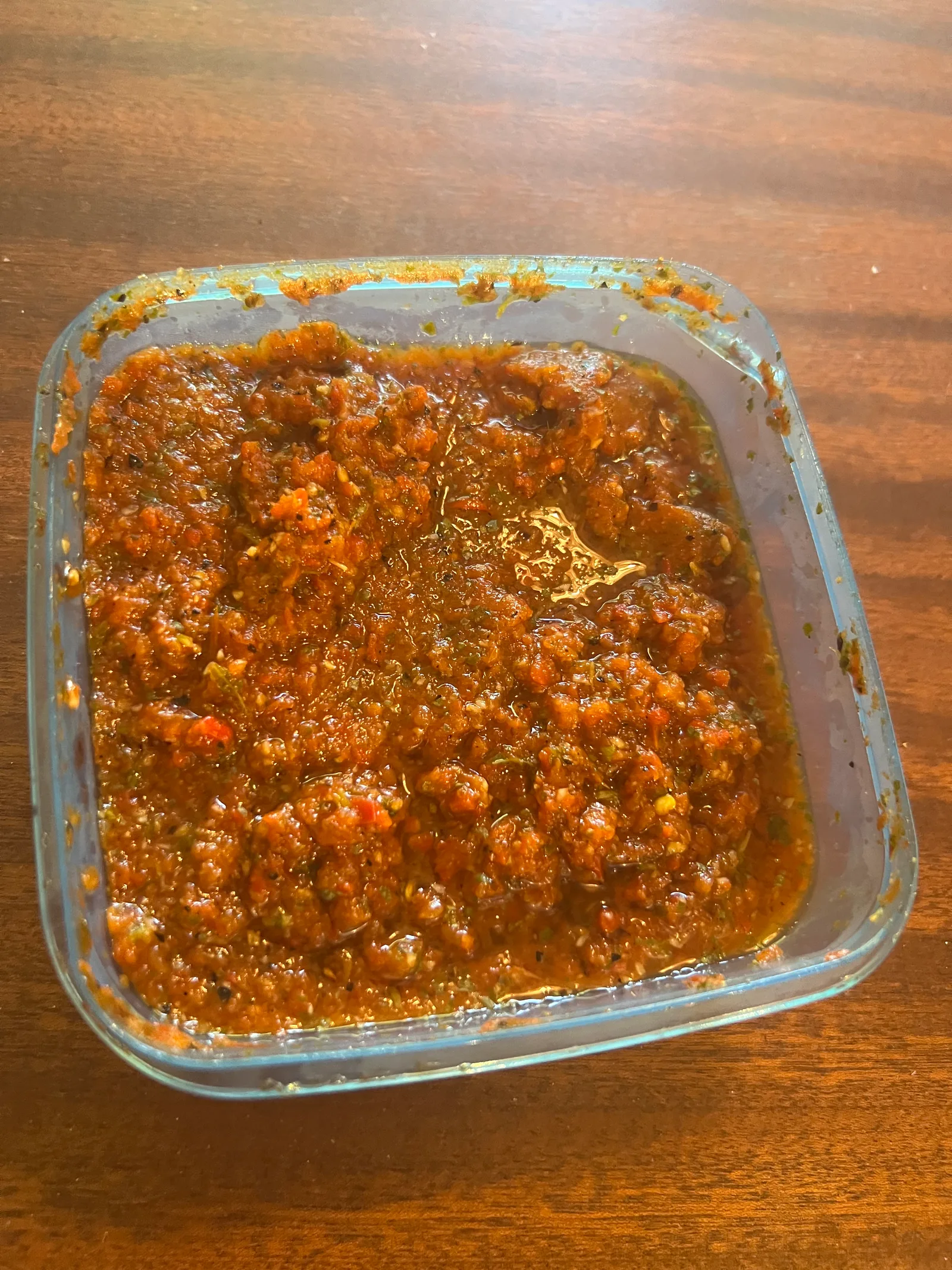 The finished chilli sauce in its well-used plastic tub.