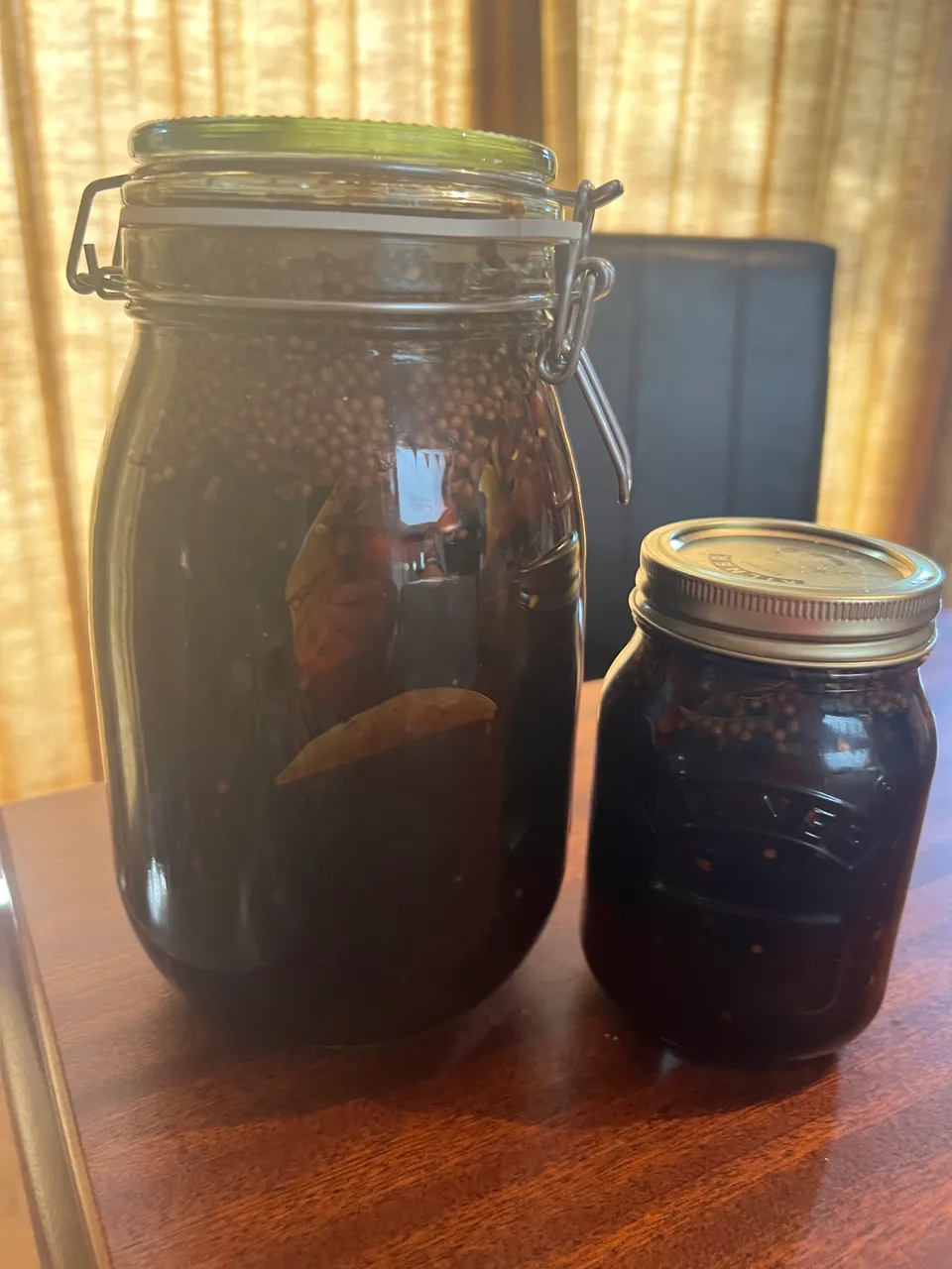 Pickled walnuts gone dark, in their jars.