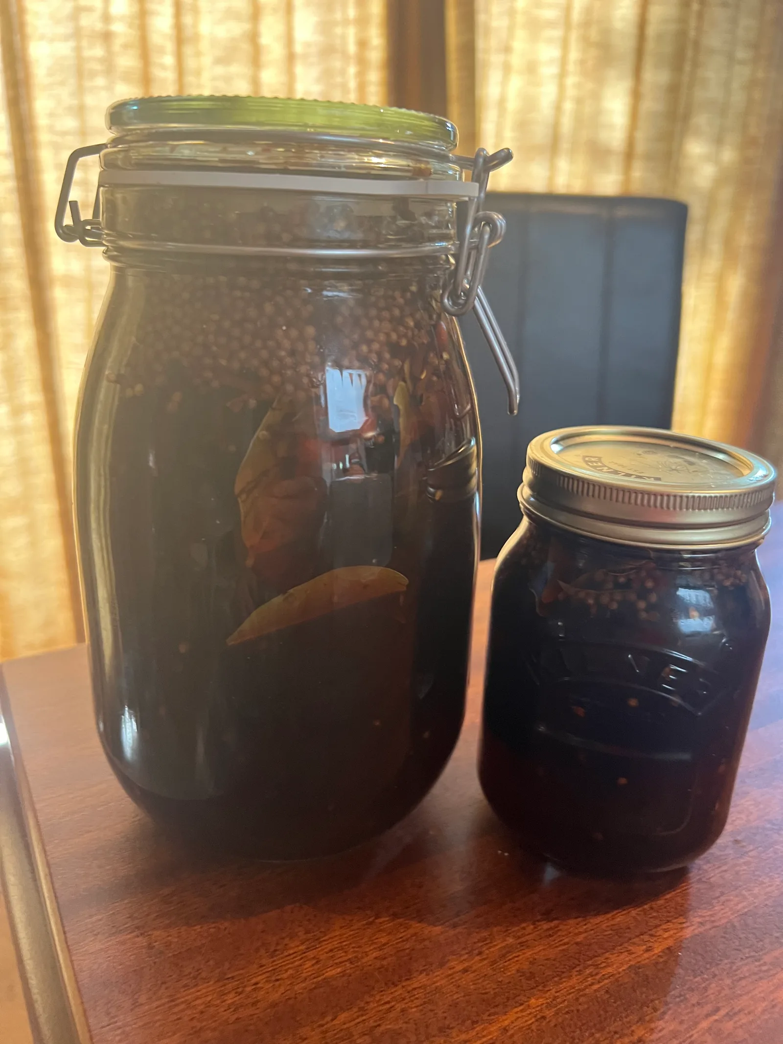 Pickled walnuts gone dark, in their jars.