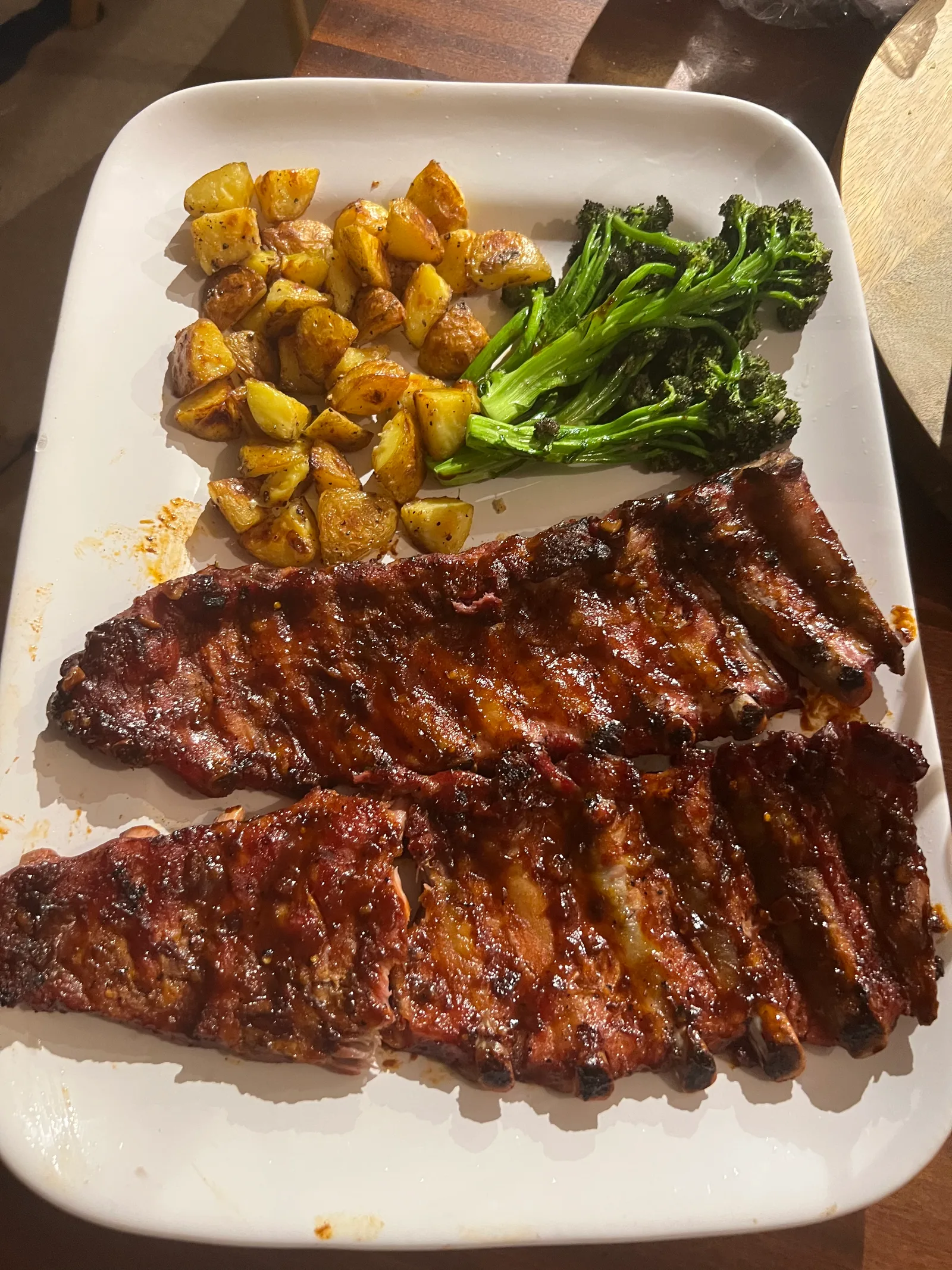 Two glazed racks of ribs with charred broccolini and roast potatoes.