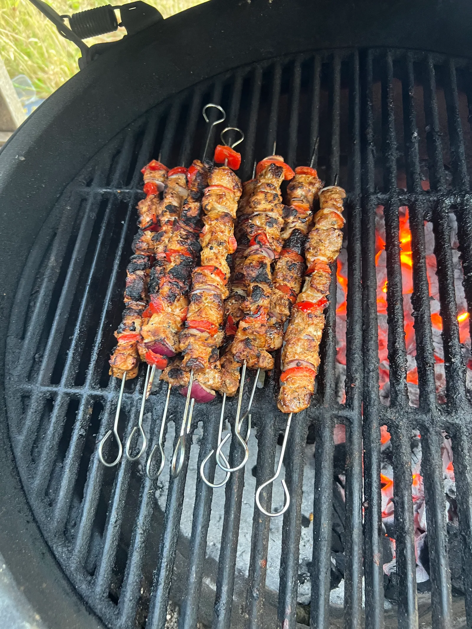Souvlaki skewers lined up over glowing coals.